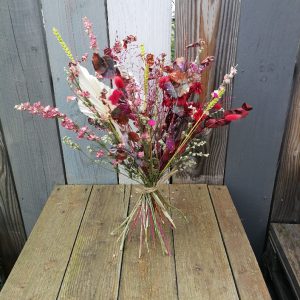 Bouquet de fleurs séchés dans les tons rouges et roses